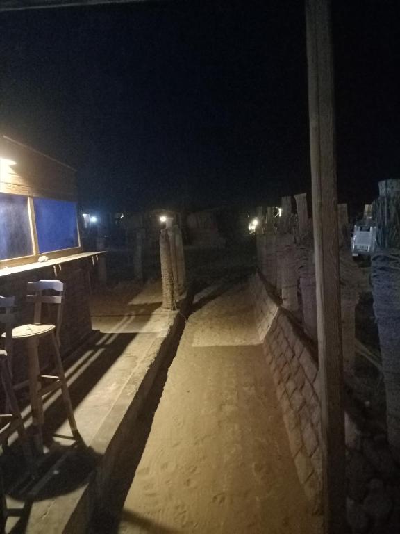 a patio at night with a table and a bar at Bella Sina Camp in Wāsiţ