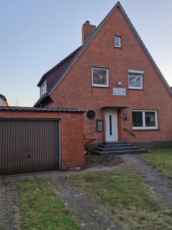 een rood bakstenen huis met een garage bij Ferienwohnung am Bürgerpark in Verden