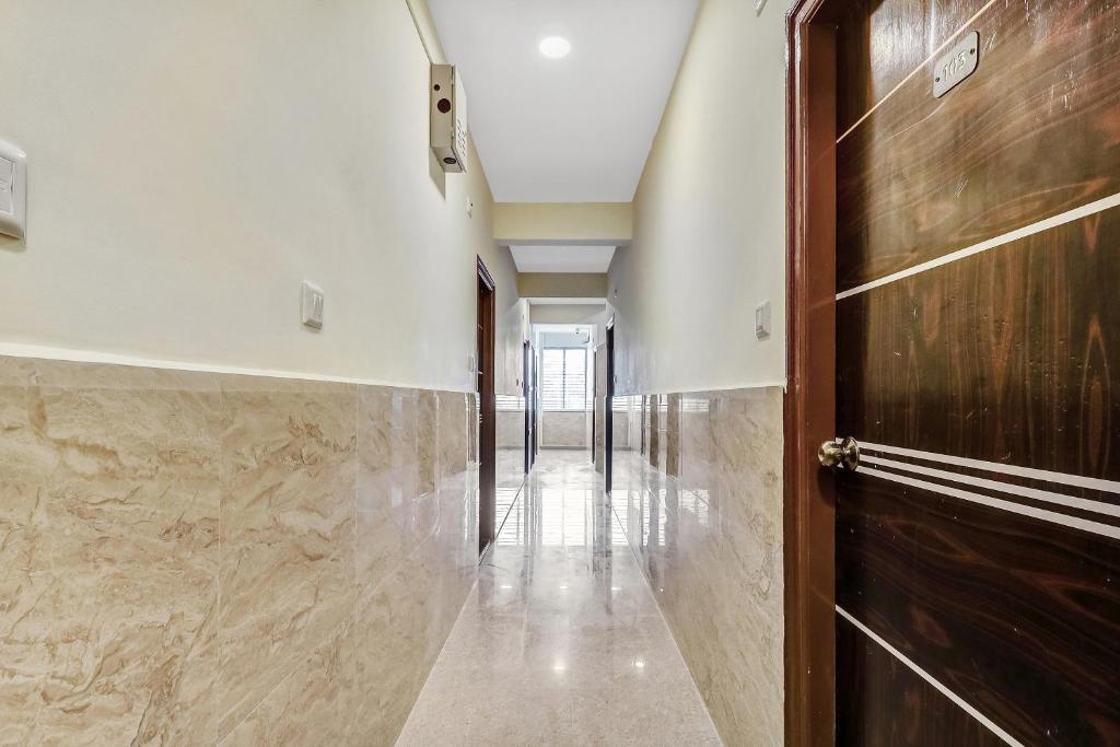 a hallway with a wooden door and a hallwayngth at Super Hotel O Royal Suites in Bengaluru