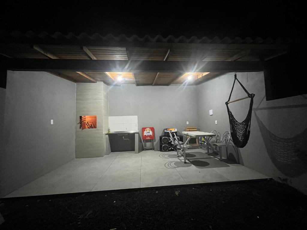 a dark room with a table in a room with lights at Geminado Praia pérola in Passo De Torres