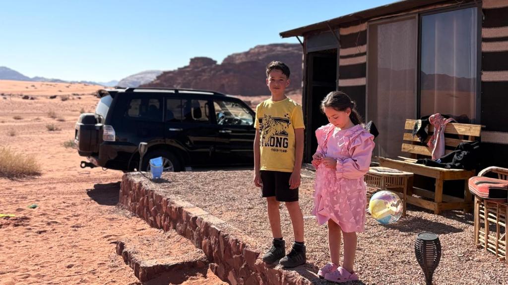 瓦迪拉姆stars magic camp的沙漠中，一男一女站在一栋建筑物旁。