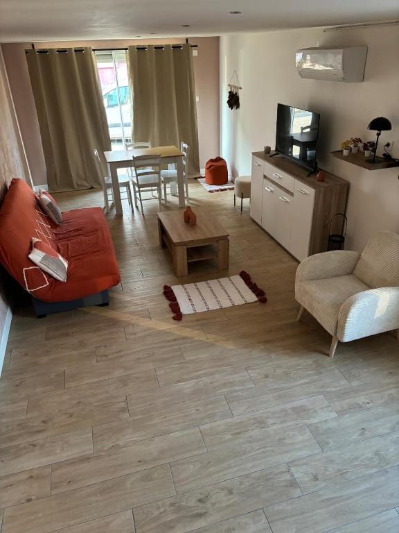 een woonkamer met een bank en een tafel bij Maison f2 avec cour privative in Montceau-les-Mines