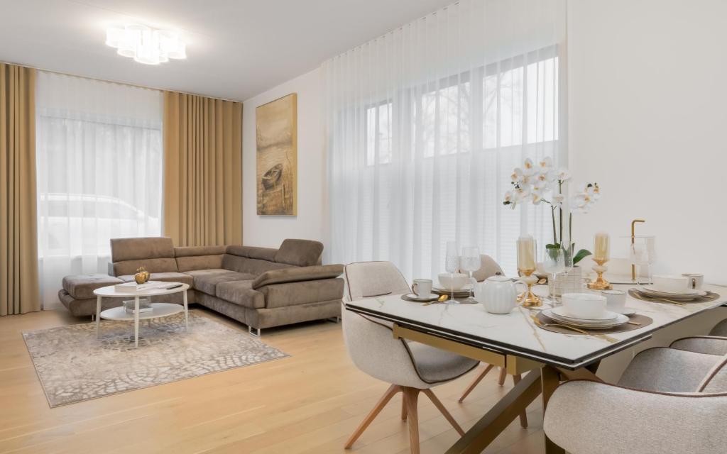 a white living room with a table and chairs at Lodja Suites in Tartu