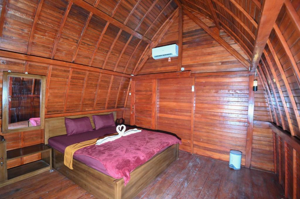 a bedroom with a bed in a wooden cabin at Laoceva vila in Padangnegeri