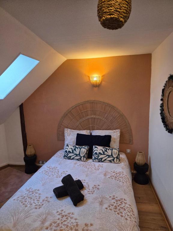 a bedroom with a bed with two black towels on it at Rêve de Loire in La Daguenière