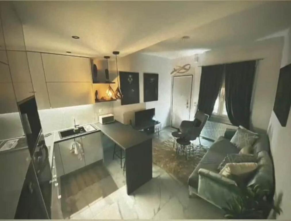 a kitchen and living room with a couch and a desk at Mimis House in Tsotílion