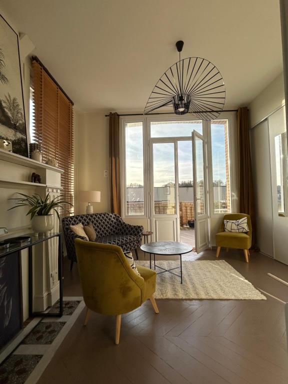 ein Wohnzimmer mit Sofa und Tisch in der Unterkunft Studio avec grande terrasse in Saint-Valéry-en-Caux