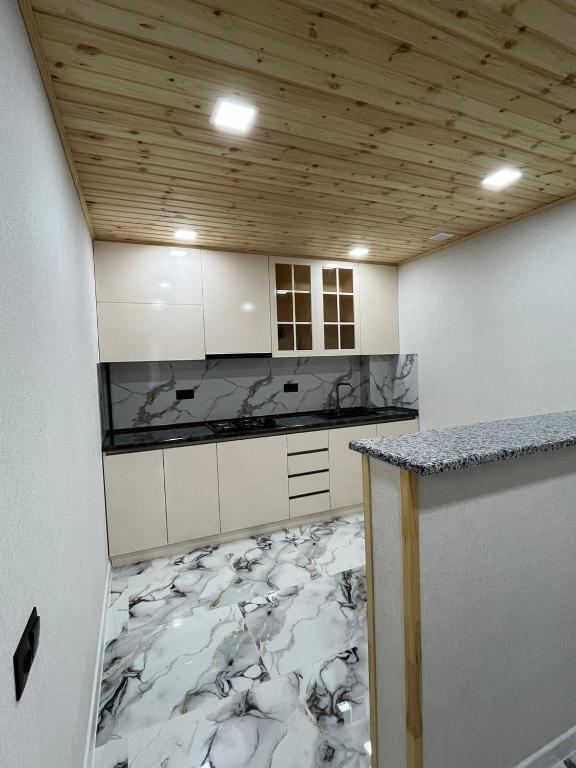 a kitchen with white cabinets and a marble floor at Дома в Дилижане in Dilijan