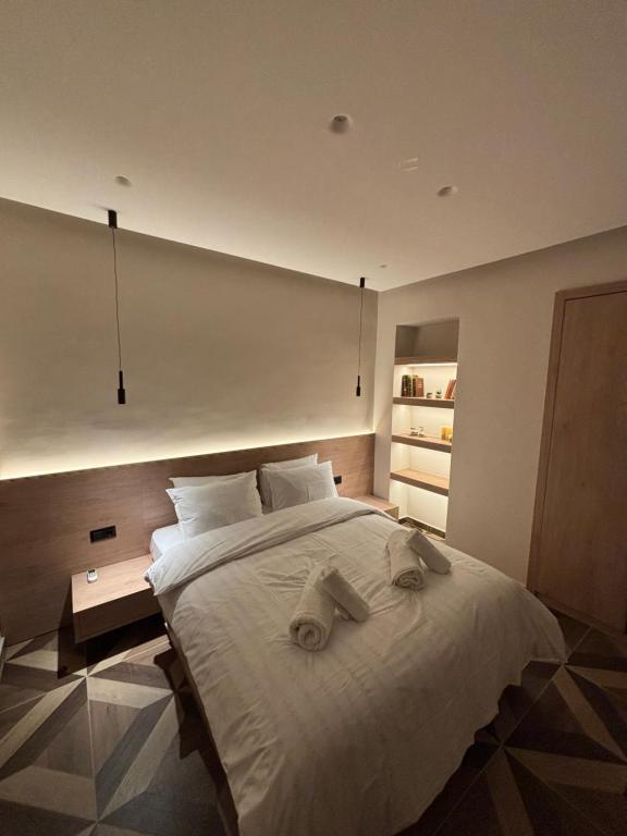 a bedroom with a large white bed with towels on it at The Cozy Residence in Veria