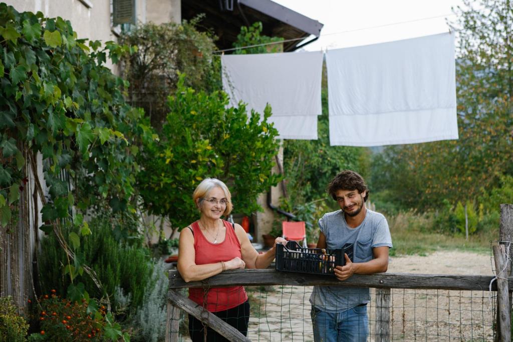un homme et une femme debout derrière une clôture en bois dans l'établissement Cascina Zan, à Paroldo