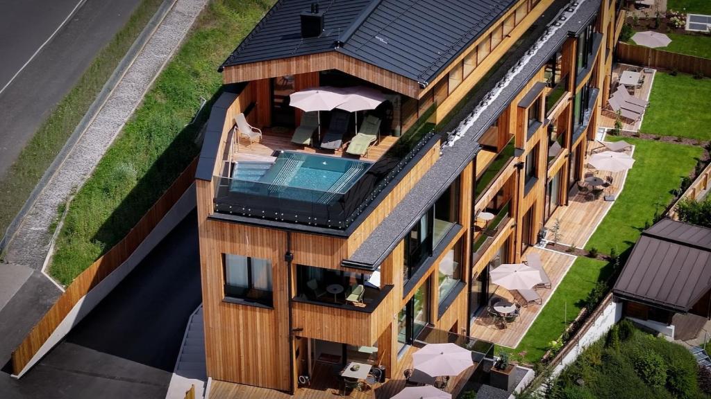 een luchtfoto van een gebouw met een zwembad bij Lärchenlodge SkySpa and Rooftop Pool inklusive Stubai SuperCard in Fulpmes