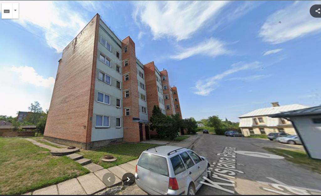 a white van parked in front of a building at Barons Street Apartment in Dobele