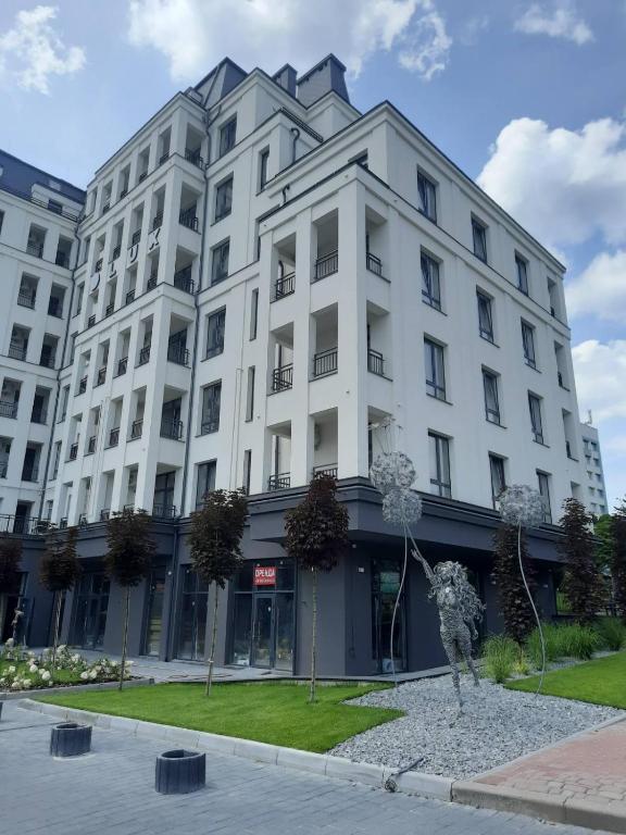 a white building with a statue in front of it at Lux Apartments in Truskavets