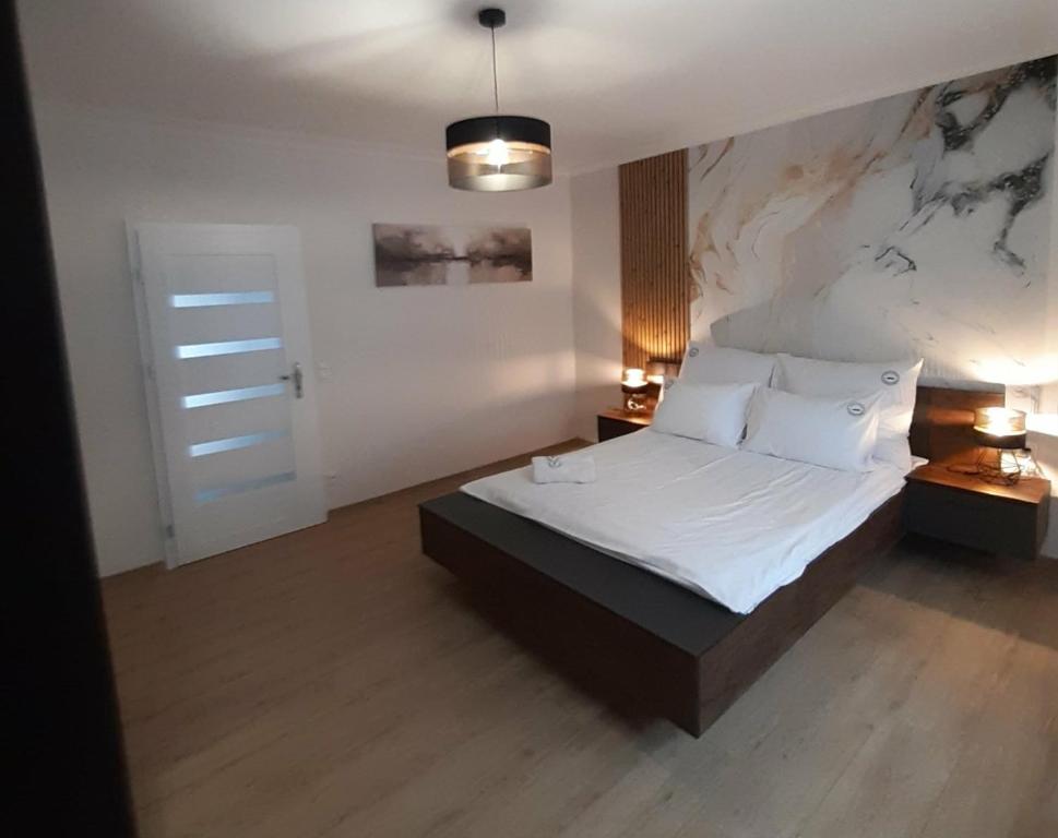 ein Schlafzimmer mit einem großen Bett mit weißen Laken und Kissen in der Unterkunft Apartament w Czarnowąsach 3 in Oppeln
