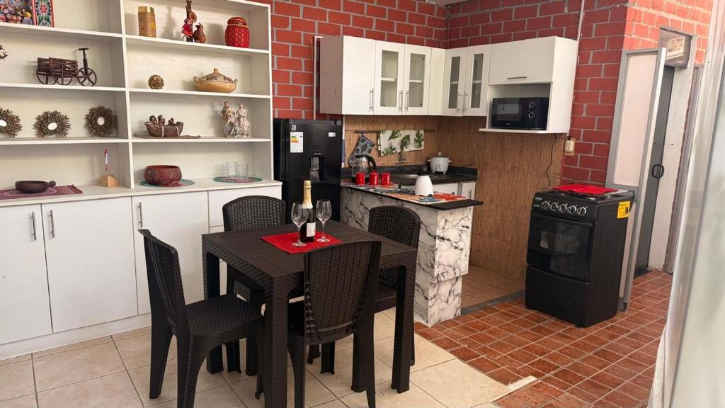 een keuken met een tafel met stoelen en een koelkast bij Curazao in Punta Hermosa