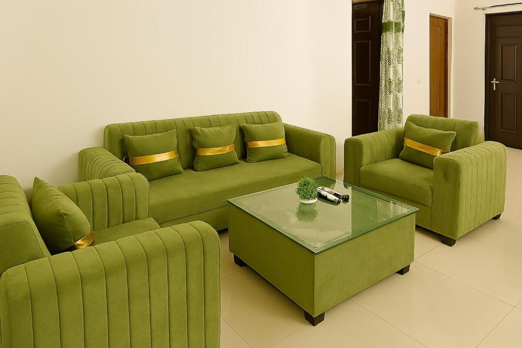 a living room with a green couch and two chairs at 2 Bhk Mayra Homes in Raipur