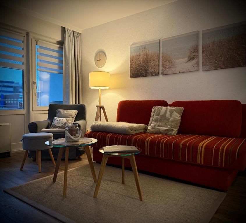 a living room with a red couch and a chair at Haus Westerhörn in Westerland