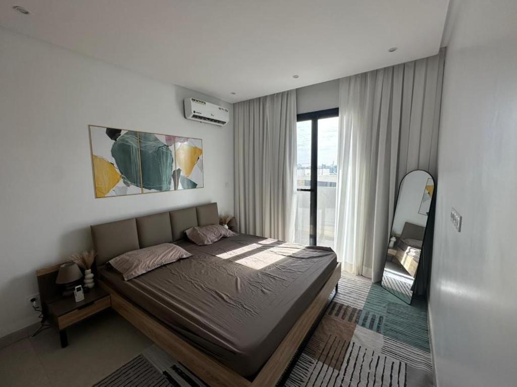 a bedroom with a bed and a large window at Studio au point E in Dakar