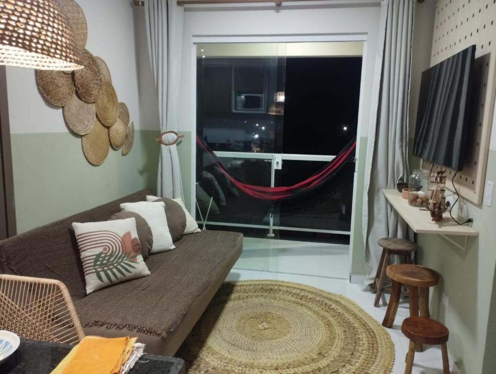 een woonkamer met een bank en een raam bij Seu refúgio em Maragogi in Maragogi