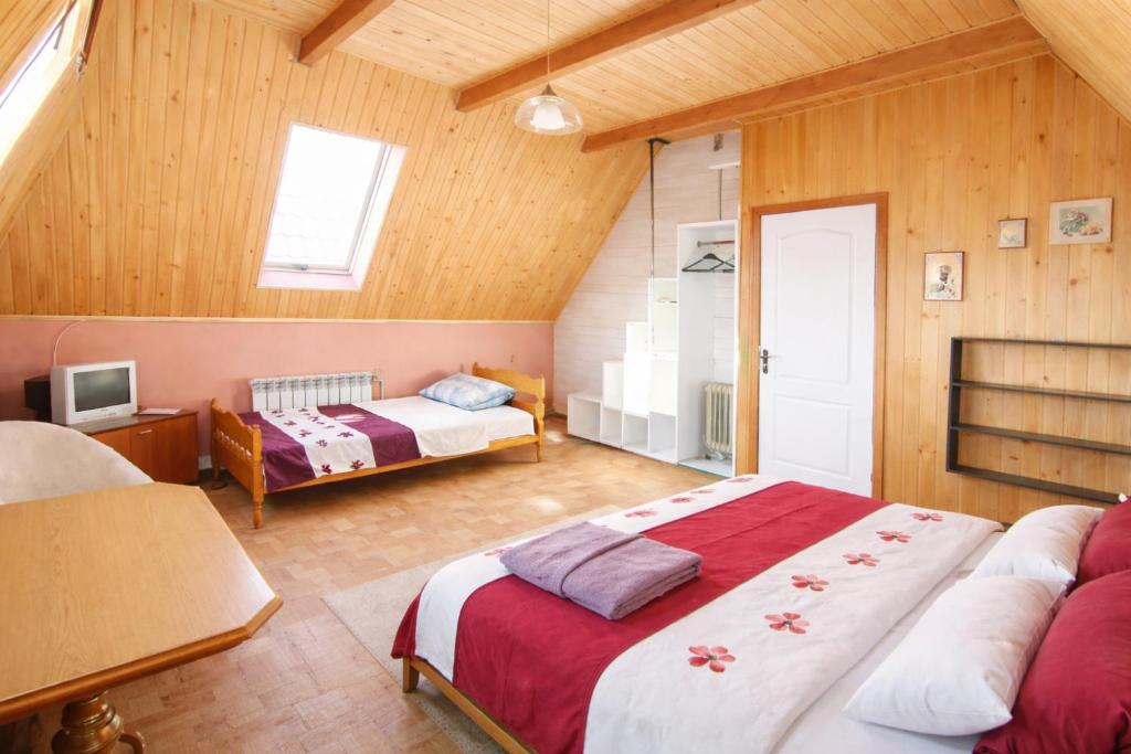 a bedroom with two beds in a room with wooden walls at Guest House Asahi in Stryi