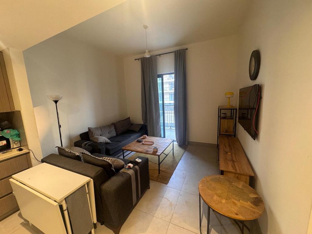 een woonkamer met een bank en een tafel bij Full apartment at excellent Community in Sharjah