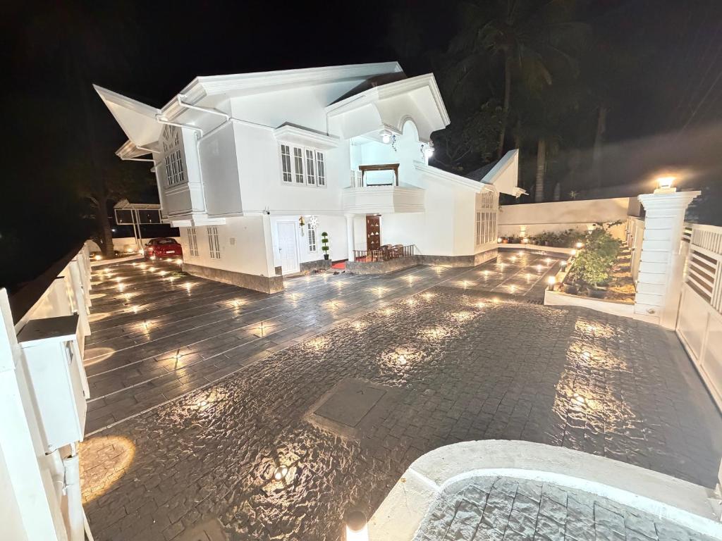 an aerial view of a white house at night at Bloom Fort Villa in Kannur