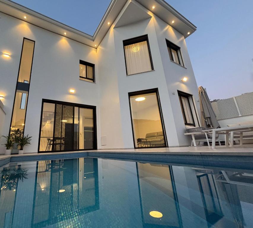 a house with a swimming pool in front of it at Sea 300 Villa in Migdal