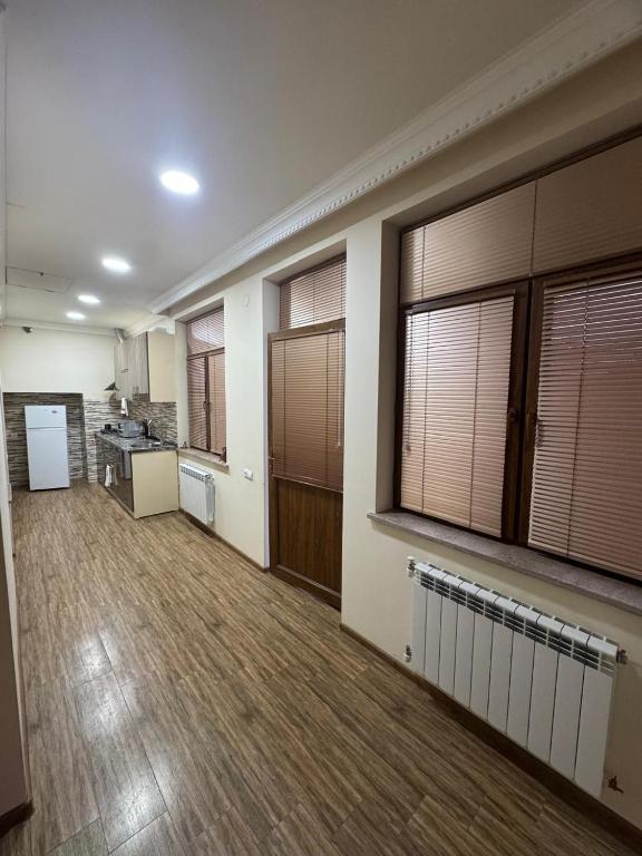 une pièce vide avec une cuisine et une grande pièce avec des fenêtres dans l'établissement NOYemi, à Goris