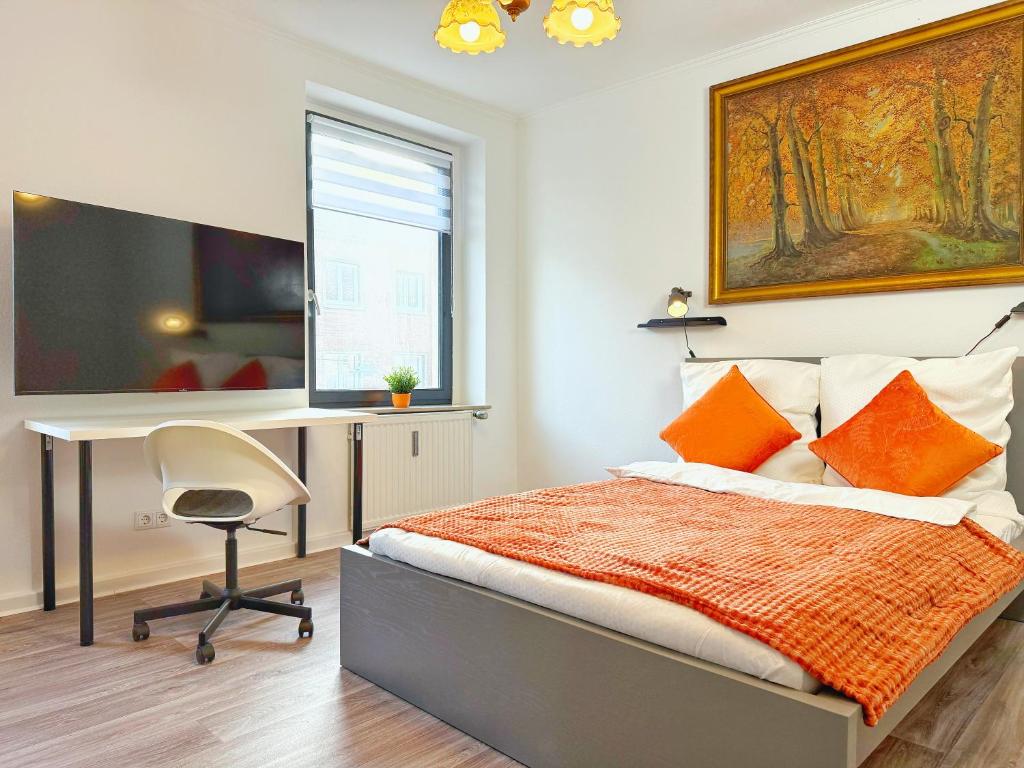 een slaapkamer met een bureau en een bed met oranje kussens bij Zentrales 2-SZ-Apartment Nr 6 - Top-Lage am HBF in Krefeld