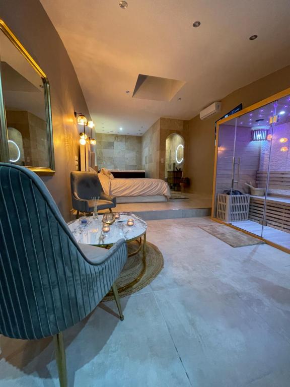 Zimmer mit Sofa, Tisch und Bett in der Unterkunft La nuit de rêve Suite privative Jaccuzi Sauna Suite 2 in Crouy