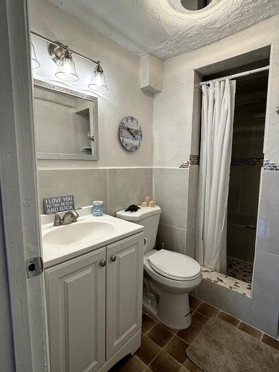 a bathroom with a toilet and a sink and a mirror at Come Chill on the Hill in Nazareth