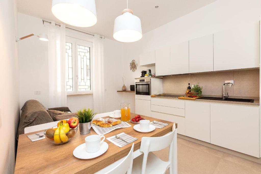 una cucina e una sala da pranzo con tavolo e frutta di Colosseum Holidays - Marco Aurelio a Roma