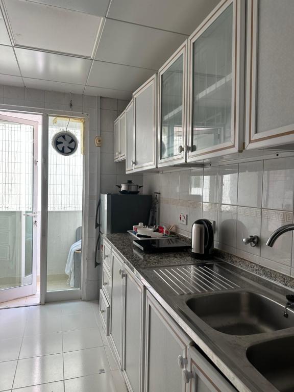 une cuisine avec des armoires blanches et un évier dans l'établissement Private double Delight Couple Room, à Abu Dhabi