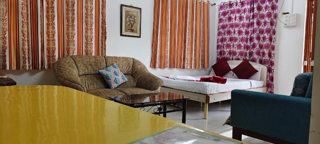 a living room with a couch and a chair at Omkar Bungalow in Alibaug
