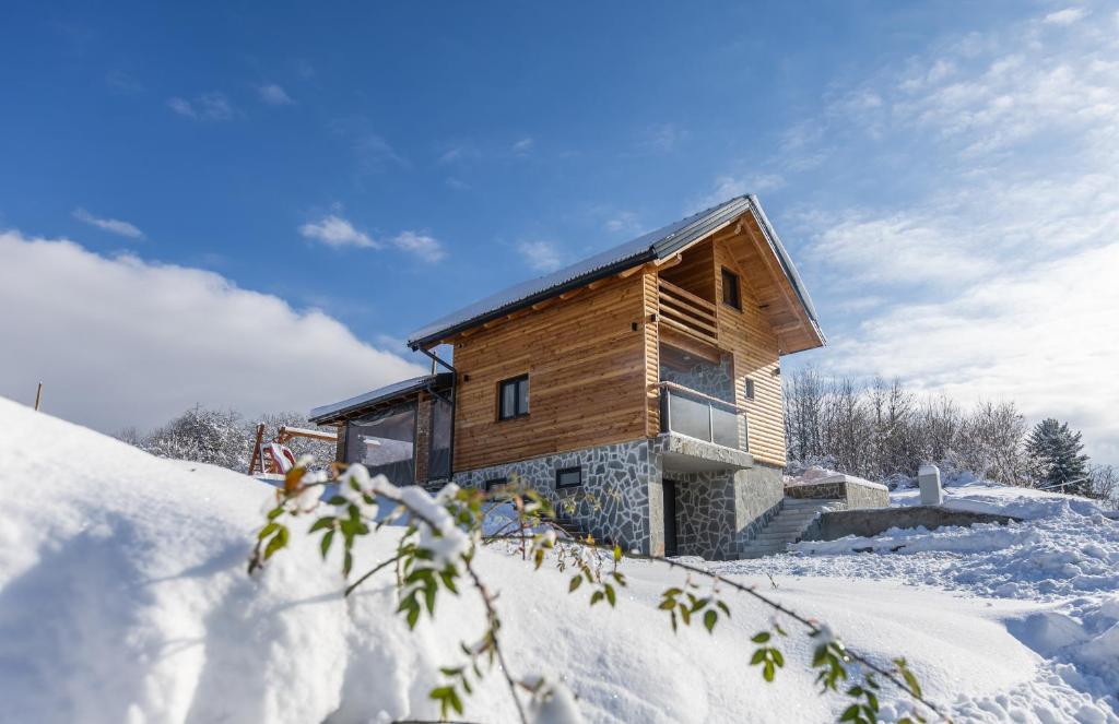 eine Holzhütte im Schnee in der Unterkunft Family Oasis, Plaški in Plaški