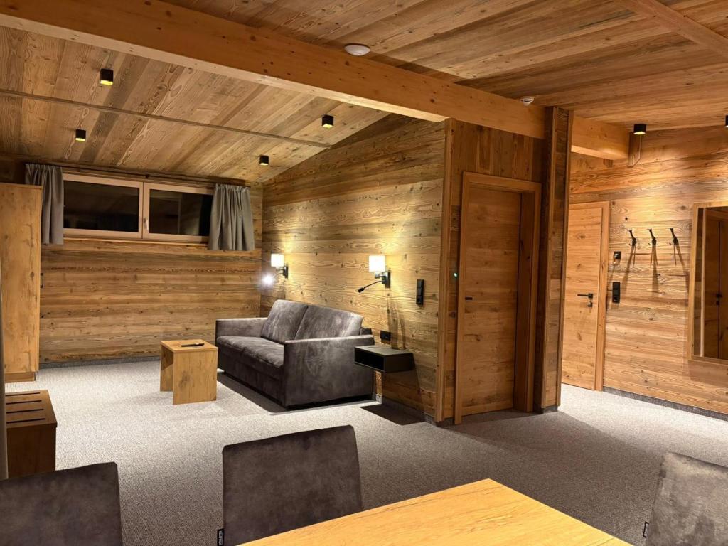 een woonkamer met houten wanden en een bank bij Alpenresort Panorama in Oberperfuss
