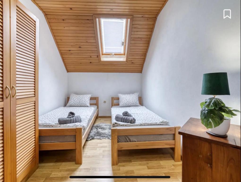 a attic room with two beds and a table at Kuća za odmor Maklen in Brod Moravice