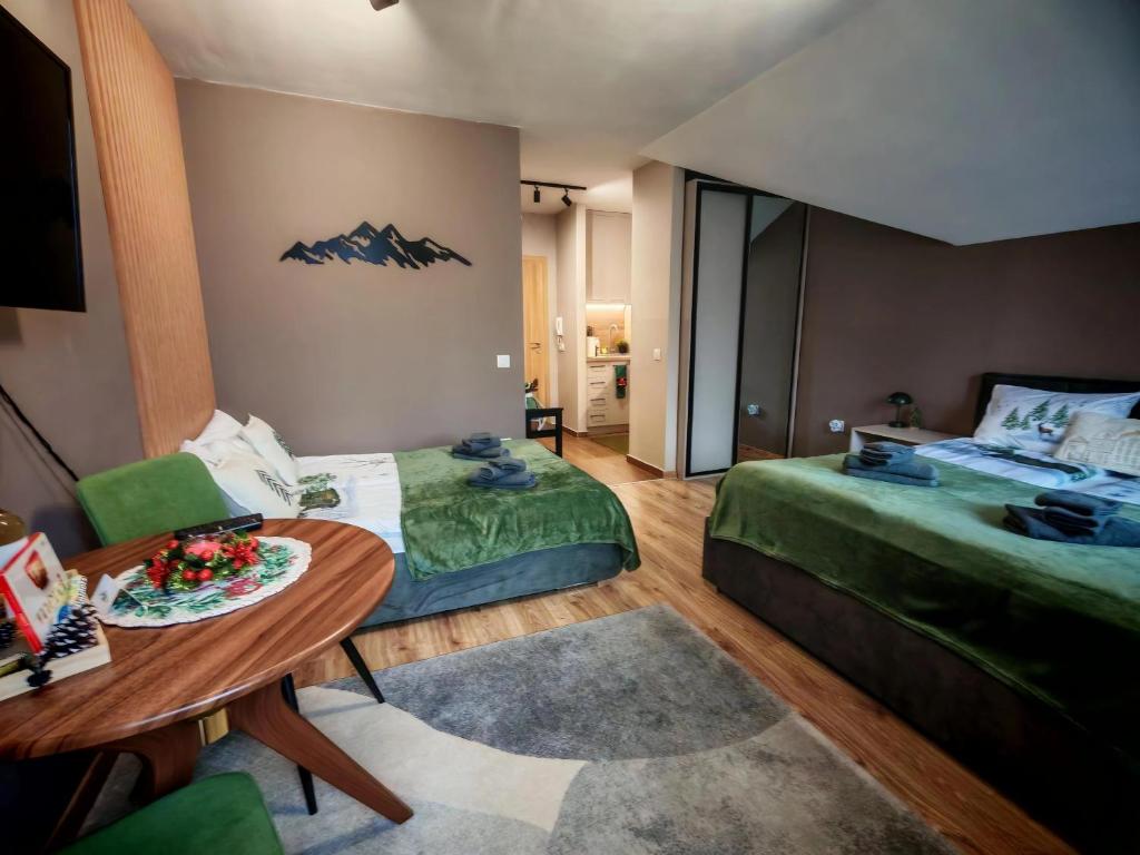 una camera d'albergo con due letti e un tavolo di Mountain studio ASP E63 Borovets Gardens a Borovets