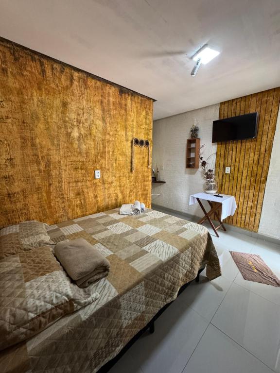 een slaapkamer met een groot bed met een muur bij Cabanas Carijó in Santarém