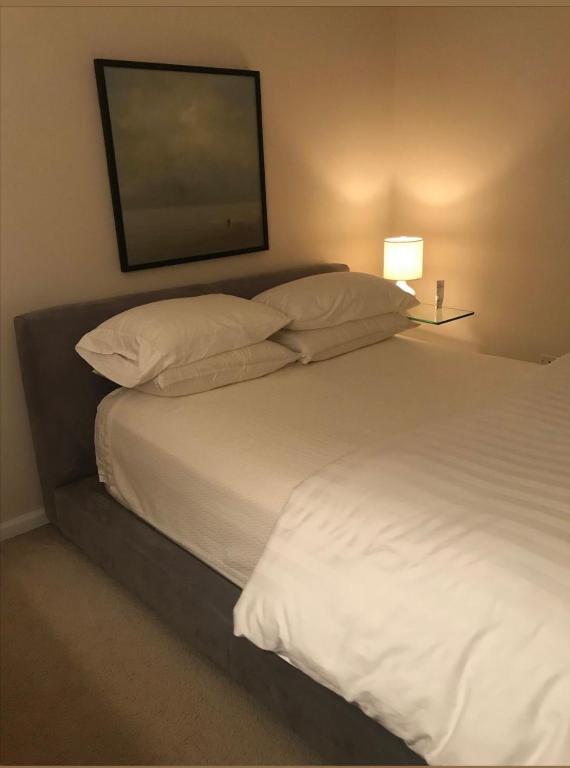 a bedroom with a white bed with a tv on the wall at Downtown Private room in Abu Dhabi