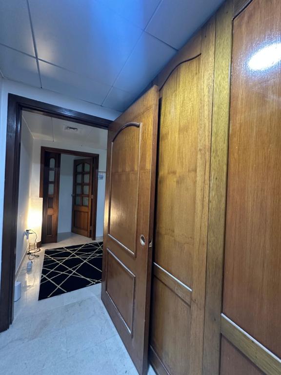 un couloir avec des murs lambrissés de bois et une porte dans l'établissement Downtown Private room, à Abu Dhabi