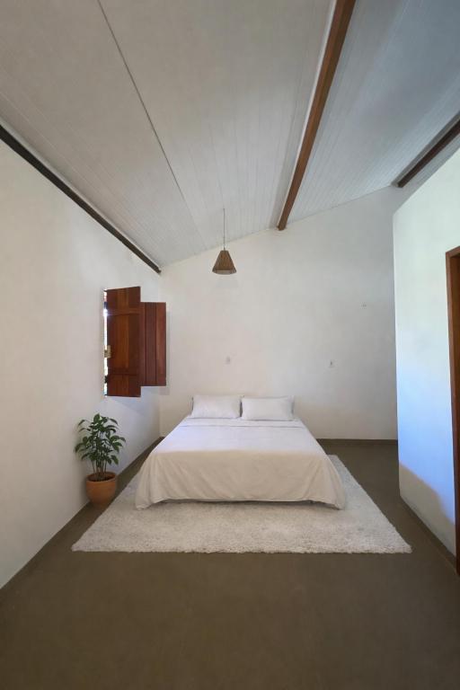 a bedroom with a bed in a white room at Recanto Caraíva in Caraíva