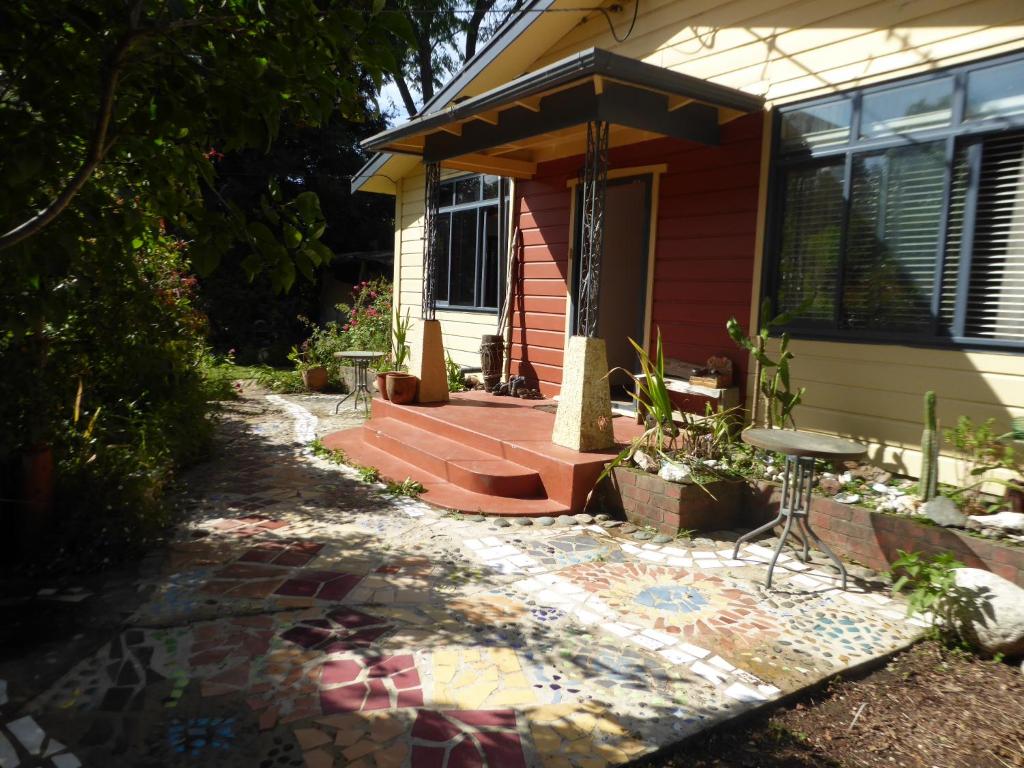 een huis met een mozaïekpad ervoor bij Dragon's den main house in Takaka
