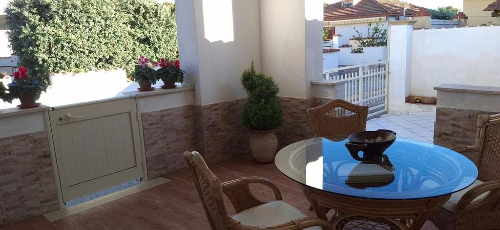 ein Zimmer mit Tisch und Stühlen und einem Balkon in der Unterkunft Villa Rosaria Triscina di Selinunte in Triscina