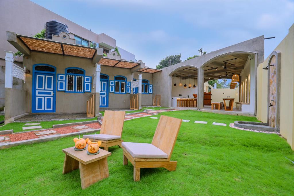 a yard with two chairs and a table in front of a house at Arcadian Weligama in Weligama