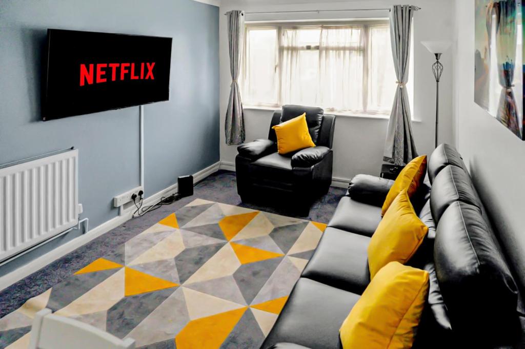 a living room with a couch and a tv at Modern 2 BR ground floor apartment with parking and garden in Belvedere