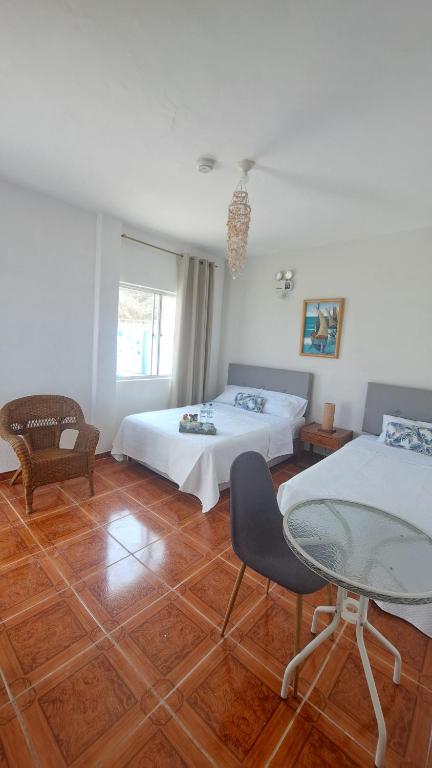 1 Schlafzimmer mit 2 Betten und einem Glastisch in der Unterkunft Residencia playa Punta Veleros in Los Órganos