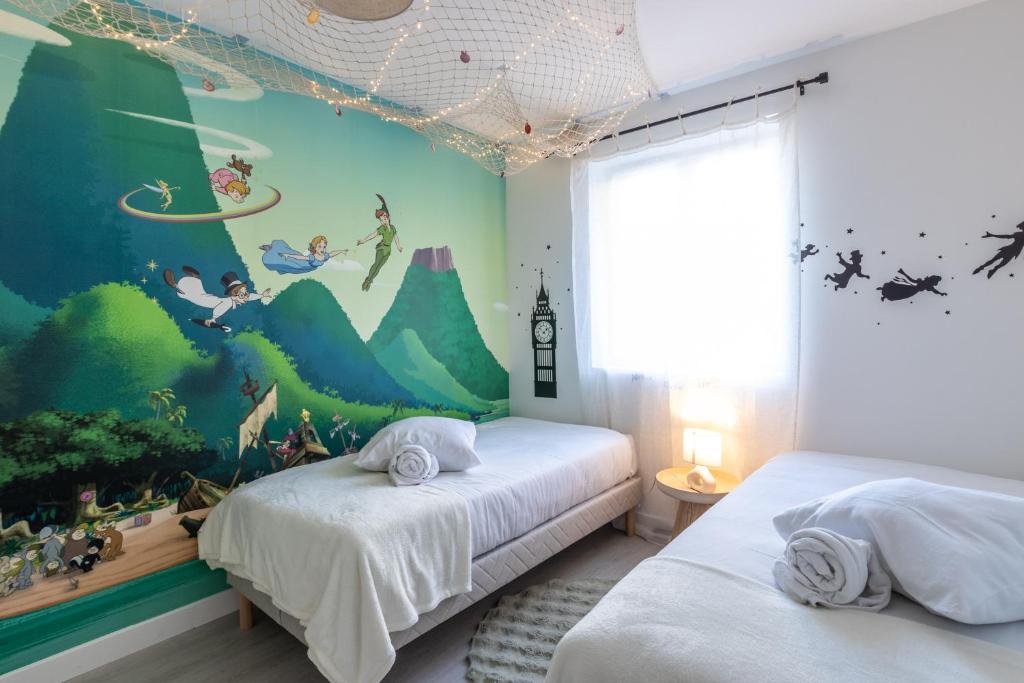 een slaapkamer met twee bedden met een muurschildering aan de muur bij Sleep & Cozy Disneyland in Coupvray