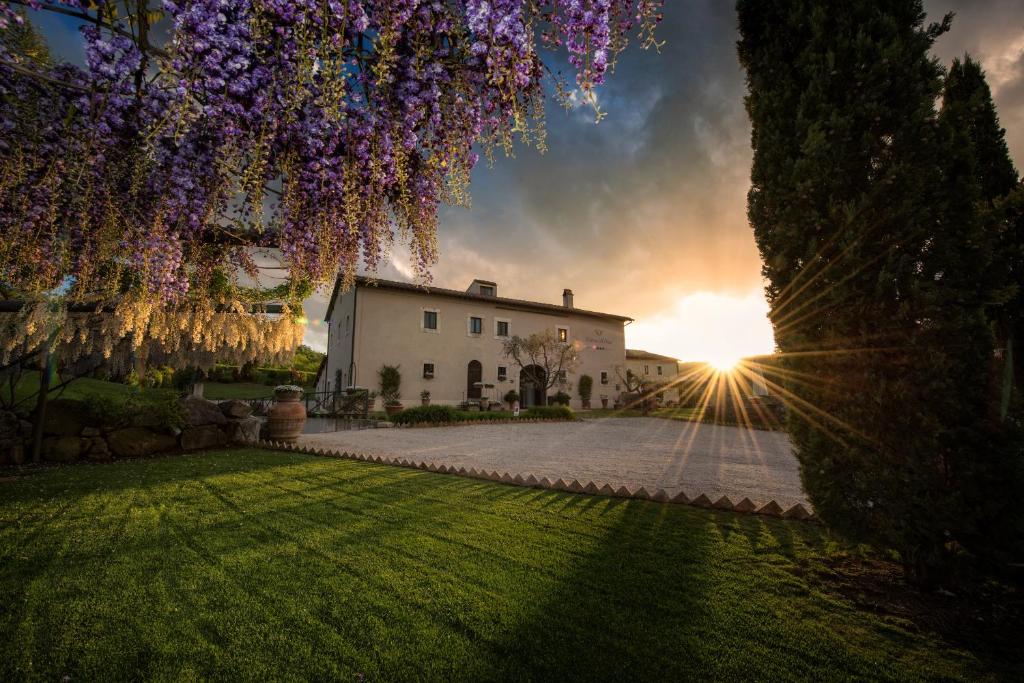 a house with the sun setting in the background at Relais Osteria Dell'Orcia in Bagno Vignoni