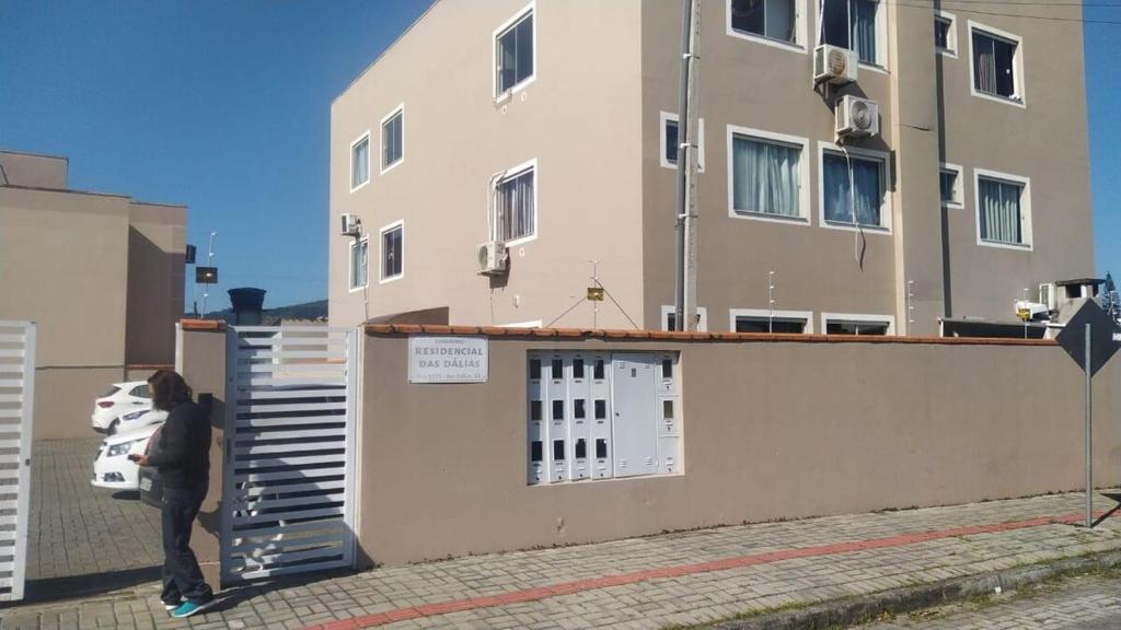 a person standing in front of a building at Aconchego Litorâneo 2 in Piçarras